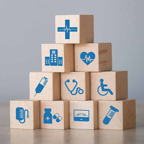 医療アイコンが描かれた木製ブロックが積み重ねられている。